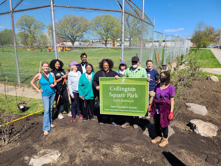 Volunteers gathered near the Collington Square Park sign after planting